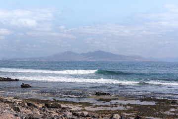 Sunny day on the coast of Fuerteventura where you can see Lanzarote in the distance in the Canary Islands in Spain