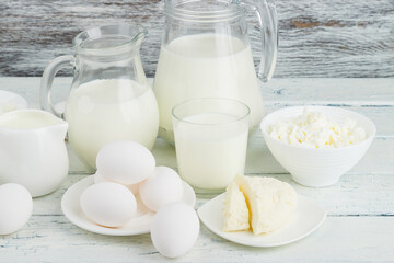 Different dairy products on the white wooden boards