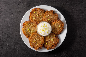 Traditional Jewish latkes or potato pancakes on black stone. Top view