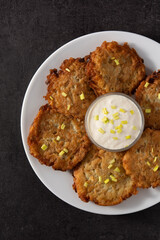 Traditional Jewish latkes or potato pancakes on black stone