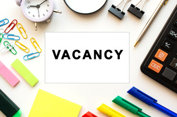 White office desk table with calculator, magnifying glass, colored pens and other stationery.