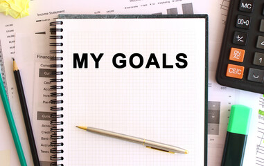 Notepad with text MY GOALS on a white background, near calculator. Business concept.