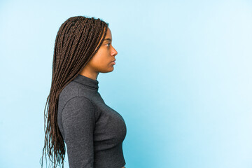 Young african american woman isolated on blue background gazing left, sideways pose.