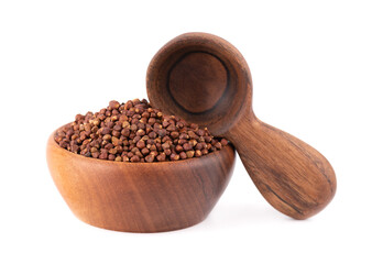 Guinea pepper grains in wooden bowl and spoon, isolated on white background. Melegeta, alligator pepper or mahlab. Grains of paradise.