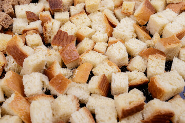 Pieces of roasted white bread on a dark background. Close-up of delicious croutons.