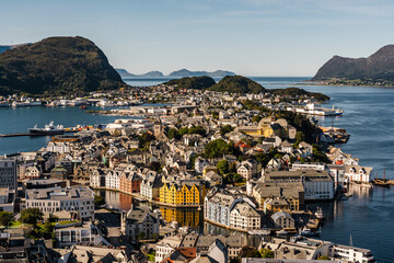 View of Ålesund in Norway on a sunny day with mountain ranges in the background - 387144597