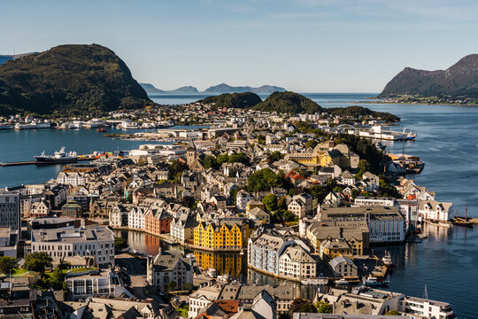View of &Aring;lesund in Norway on a sunny day with mountain ranges in the background