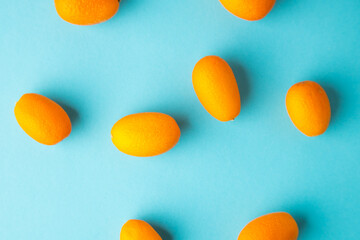 orange kumquat fruit on blue background