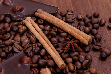 Chocolate bar with nuts on a wooden table with coffee beans and spices. Roasted coffee beans,...