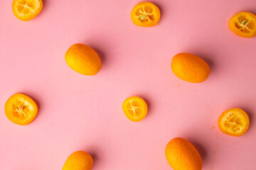 Fototapeta na wymiar kumquat orange fruit on pink background