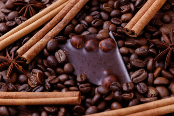 Chocolate bar with nuts on a wooden table with coffee beans and spices. Roasted coffee beans,...