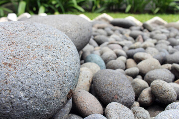 Obraz na płótnie Canvas Big stones among smaller pebbles, in the garden
