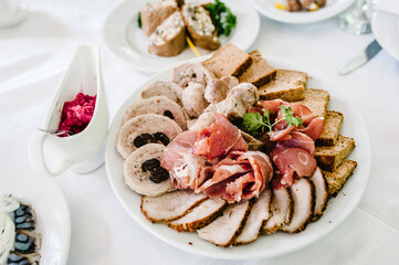 Meat slicing with delicious salami, pieces of sliced ham, meat, pate, sausages. Meat platter with selection. Cold smoked meat plate with bacon, pork chops. top view