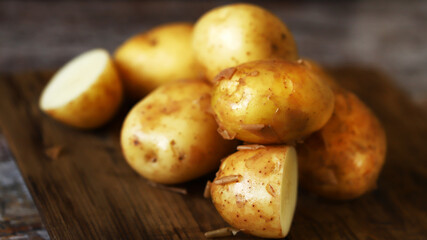 Fresh raw potatoes on a wooden surface.