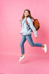 Young student woman going to school isolated on pink background