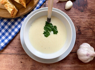Creamy, healthy garlic soup, served with basil and white bread.