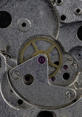Vintage watch movement close - up. Selective focus on elements, macro photography. Background in steampunk style. Metallic grunge texture. Easy image tinting