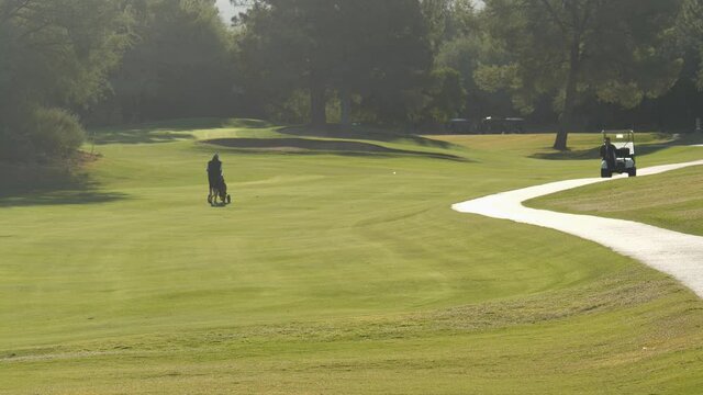 A man walking a fairway at a golf course