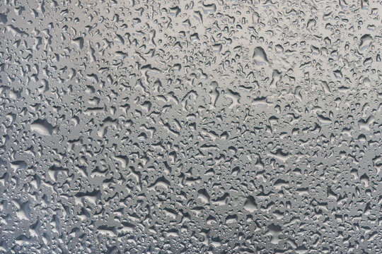 water drops on glass background texture. rain on the grey window