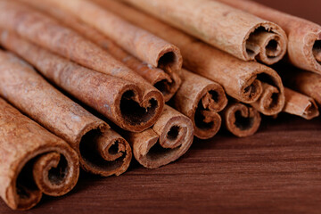 Cinnamon sticks closeup on dark wood background.