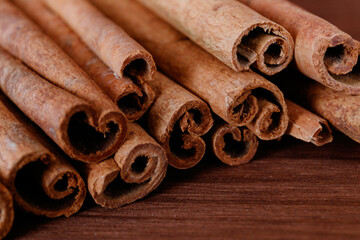 Obraz na płótnie Canvas Cinnamon sticks closeup on dark wood background.