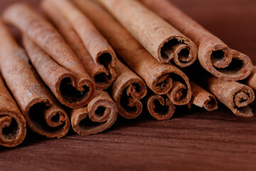 Cinnamon sticks closeup on dark wood background.