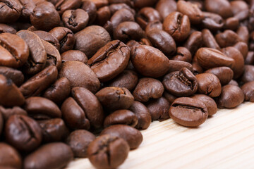 Obraz premium Fresh roasted coffee beans on wooden table. Macro shot.