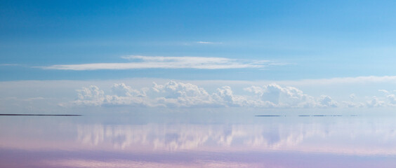 Pink salt lake water with clouds and blue sky