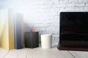 stack of books and laptop on table 