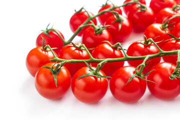 Clusters of small red cherry tomatoes on a white background