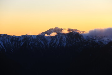 北アルプス燕岳山頂から　夕陽に沈む笠ヶ岳、裏銀座コース稜線を望む