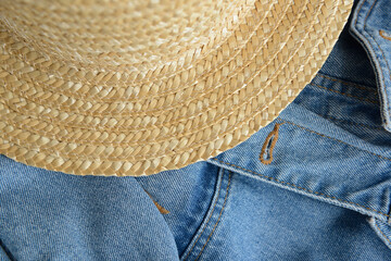 Straw hat on blue denim texture background