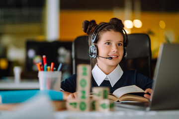 Stylish school girl sitting at the table with books. Self-isolation, online education concept, home schooler. Covid-2019.