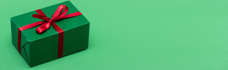 website header of gift box with red ribbon on green background with copy space