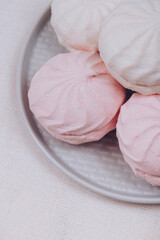Tasty sweet zephyr on a plate and tablecloth background.