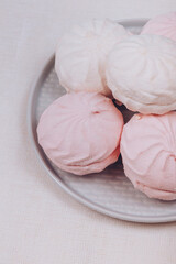 Tasty sweet zephyr on a plate and tablecloth background.