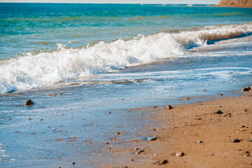  Sunny landscape of seaside shore with view of sandy beach, waves, cape Chameleon. Black Sea, Crimea