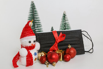 Medical mask as gift with a red ribbon and ornament on white background, COVID 19 protection ,The concept of health care in the Christmas Festival