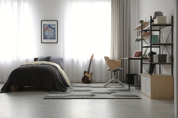 Modern teenager's room interior with workplace and bed