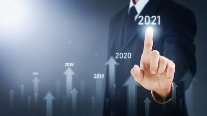 Obraz premium Man standing and pointing hand with Arrow and Line Visual Graphic on Light of Len flare and Boke blue background. COPY SPACE. Business Concept : Market Uptrend 2021.