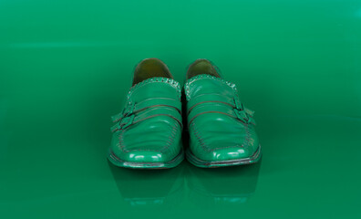 green men's shoes on a green background