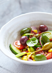 Simple Salad with Green and Kalamata Olives, Cucumber, Cherry and marinated Tomatoes, Capers and Jalapeno Pepper. Close up. 