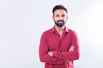 Handsome Indian man looking at camera over white studio background