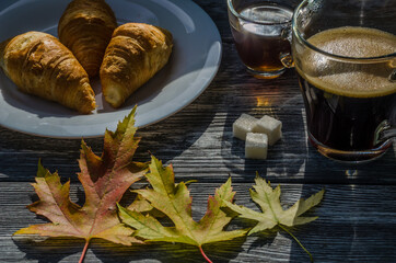 Still life with cup of coffee and fallen leaves and sweets