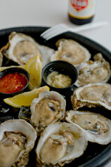 Oysters on the half shell. Fresh oysters served with garlic, shallots, cocktail sauce, mignonette sauce and fresh lemons and limes. Classic American steakhouse or French bistro appetizer.
