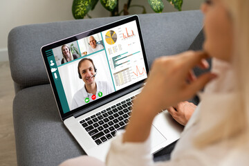 Back view of business woman talking to her colleagues about plan in video conference. Multiethnic business team using laptop for a online meeting in video call. Group of people smart working from home