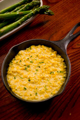 Steakhouse side dishes. Asparagus, salad, tomatoes, mashed potatoes, red onions, cream cauliflower, pickled peppers, seasoned meats served in cast iron skillet. Traditional appetizer items.