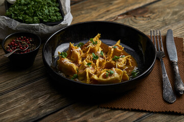 Italian ravioli stuffed with meat closeup on a black plate. rustic style