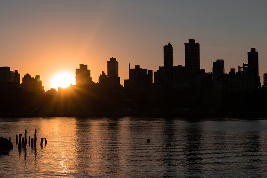 Sunset over the Silhouettes of Skyscrapers in the Upper East Side Skyline along the East River in New York City