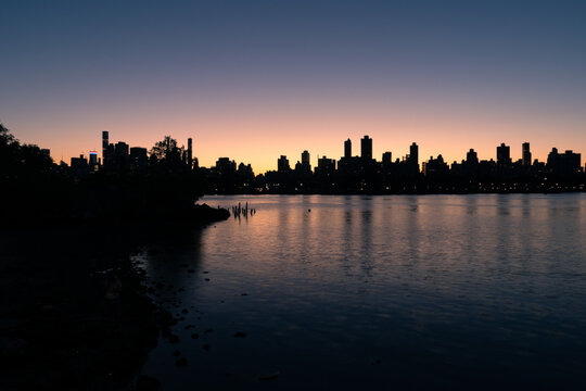 Silhouettes of Skyscrapers in the Upper East Side and Manhattan Skyline along the East River in New York City after a Sunset
